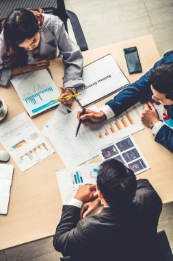 İş adamları grup toplantısı ofiste yukarıdan çekildi. İş kadınları, iş adamları ve ofis çalışanları, proje planlama belgeleriyle takım konferansında toplantı masasında çalışıyorlar. .