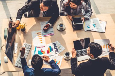 İş adamları grup toplantısı ofiste yukarıdan çekildi. İş kadınları, iş adamları ve ofis çalışanları, proje planlama belgeleriyle takım konferansında toplantı masasında çalışıyorlar. .