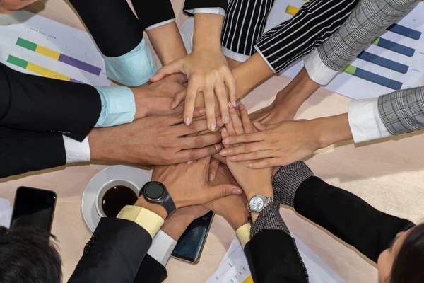 Happy business people celebrate teamwork success together with joy at office table shot from top view . Young businessman and businesswoman workers express cheerful victory showing unity and support .