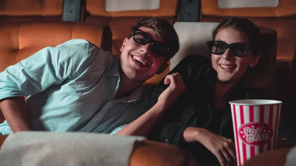 3Dメガネで映画を見ている映画館の男と女 画面を見て興味を持ちポップコーンを食べ — ストック写真
