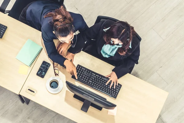 Ofiste üst kademeden kulaklık takan işadamları uzak müşteri ya da meslektaşlarını desteklemek için bilgisayarla çalışıyorlar. Çağrı merkezi, tele pazarlama acente servisi telefon ya da video konferans çağrısı.
