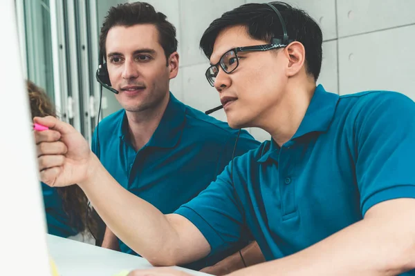 Ofiste çalışan kulaklık takan işadamları uzak müşteri ya da meslektaşlarını desteklemek için çalışıyorlar. Arama merkezi, tele pazarlama, müşteri destek acentesi telefon görüşmesinde hizmet sunar.