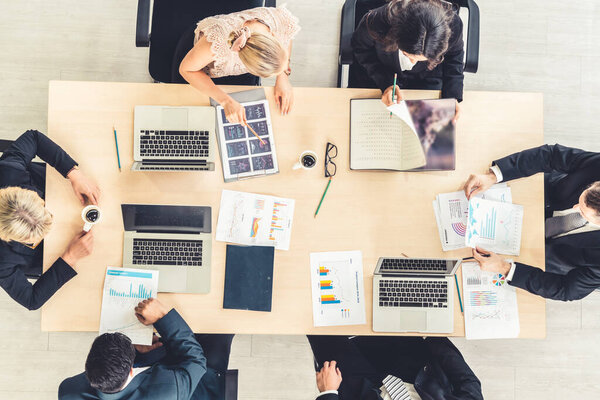 Business people group meeting shot from top view in office . Profession businesswomen, businessmen and office workers working in team conference with project planning document on meeting table .