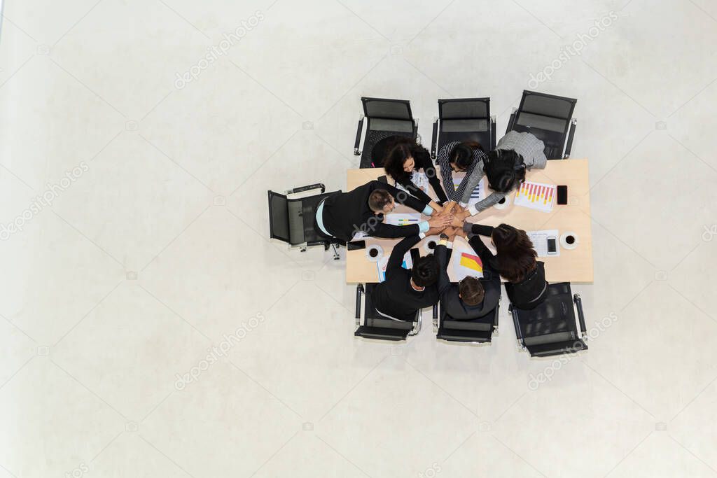 Happy business people celebrate teamwork success together with joy at office table shot from top view . Young businessman and businesswoman workers express cheerful victory showing unity and support .