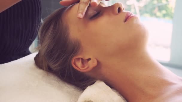 Mujer recibe masaje facial y de cabeza en spa de lujo. — Vídeo de stock