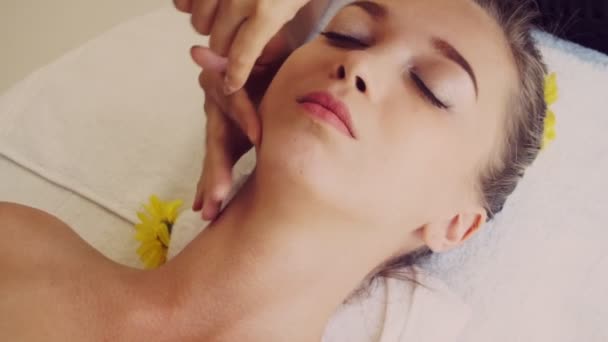 Mulher recebe massagem facial e na cabeça no spa de luxo. — Vídeo de Stock