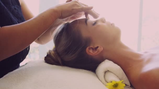 Mujer recibe masaje facial y de cabeza en spa de lujo. — Vídeos de Stock