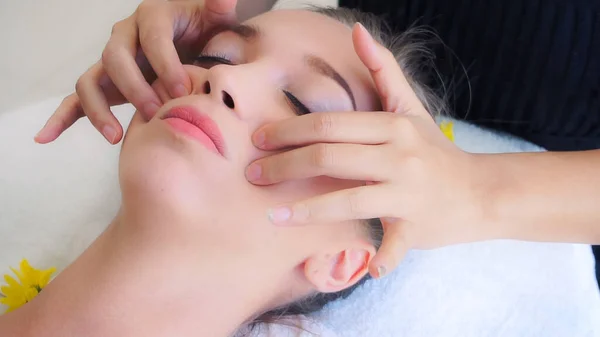Mujer recibe masaje facial y de cabeza en spa de lujo. — Foto de Stock