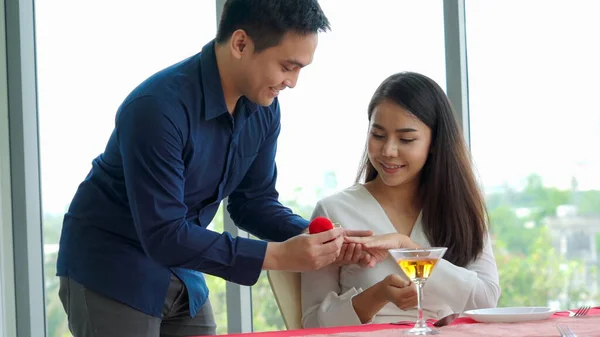 Romantic couple giving gift to lover at restaurant — Stock Photo, Image