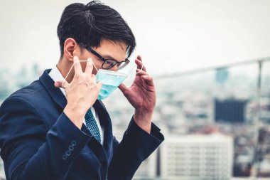 Coronavirus ya da COVID-19 yüzünden yüz maskesi olan genç bir ofis çalışanı..