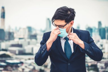 Coronavirus ya da COVID-19 yüzünden yüz maskesi olan genç bir ofis çalışanı..