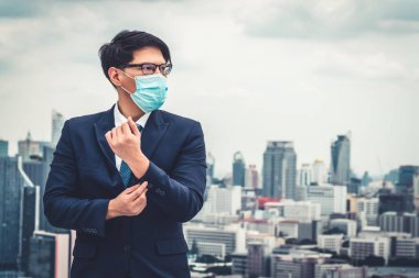 Coronavirus ya da COVID-19 yüzünden yüz maskesi olan genç bir ofis çalışanı..