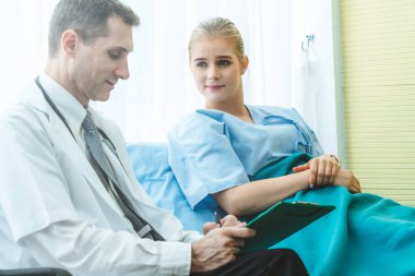 Profesyonel üniformalı doktor hastanedeki hastayı muayene ediyor.