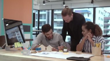 Yaratıcı iş adamları grubu iş yerindeki ofis masasında sohbet ediyorlar..