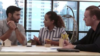 Yaratıcı iş adamları grubu iş yerindeki ofis masasında sohbet ediyorlar..