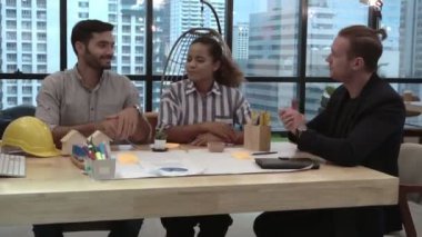 Yaratıcı iş adamları grubu iş yerindeki ofis masasında sohbet ediyorlar..