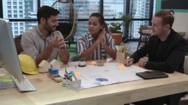 Yaratıcı iş adamları grubu iş yerindeki ofis masasında sohbet ediyorlar..