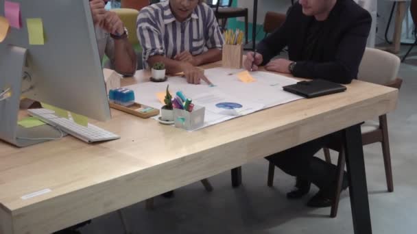 Gruppo creativo di uomini d'affari che conversano alla scrivania dell'ufficio sul posto di lavoro. — Video Stock