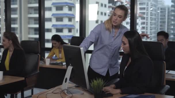 Jonge leider geeft advies aan jonge vrouwelijke werknemer. — Stockvideo