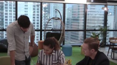 Yaratıcı iş adamları grubu iş yerindeki ofis masasında sohbet ediyorlar..