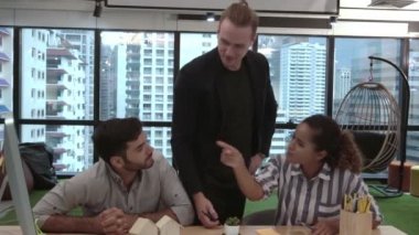 Yaratıcı iş adamları grubu iş yerindeki ofis masasında sohbet ediyorlar..