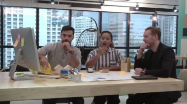 Yaratıcı iş adamları grubu iş yerindeki ofis masasında sohbet ediyorlar..