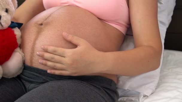 Mujer embarazada feliz y esperando un bebé en casa. — Vídeos de Stock