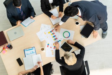 İş adamları grup toplantısı ofiste yukarıdan çekildi. İş kadınları, iş adamları ve ofis çalışanları, proje planlama belgeleriyle takım konferansında toplantı masasında çalışıyorlar. .