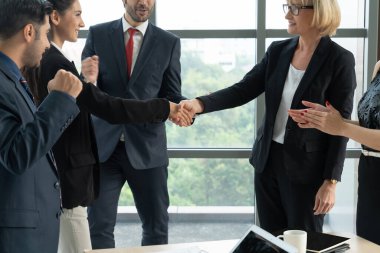 Şirket ofisinde iş adamlarının el sıkışması mali anlaşma konusunda profesyonel bir anlaşma gösteriyor.
