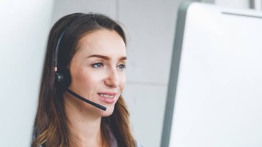 Ofiste çalışan kulaklık takan işadamları uzak müşteri ya da meslektaşlarını desteklemek için çalışıyorlar. Arama merkezi, tele pazarlama, müşteri destek acentesi telefon görüşmesinde hizmet sunar.