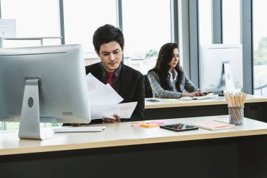 Modern ofis odasındaki masada çalışan iş adamları mali veri raporlarını incelerken .