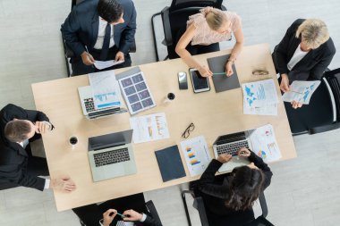 İş adamları grup toplantısı ofiste yukarıdan çekildi. İş kadınları, iş adamları ve ofis çalışanları, proje planlama belgeleriyle takım konferansında toplantı masasında çalışıyorlar. .