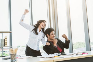 İki mutlu iş adamı ofis toplantı odasında kutlama yapıyor. Başarılı iş adamı, mali veri raporu üzerinde konuşurken modern işyerindeki meslektaşlarıyla proje başarısını kutladı.