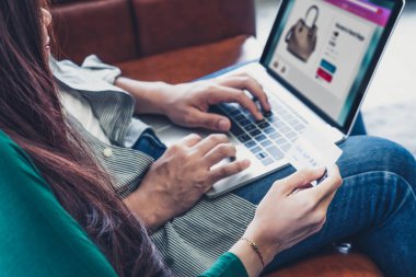 Genç çift evdeki internet sitesinden online alışveriş için kredi kartını kullanıyor. Kredi kartındaki numara sahte. Kredi kartında kişisel bilgi yok. Çevrimiçi iş alışveriş kavramı.