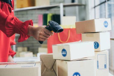 Çevrimiçi satıcı ev ofisinde çalışıyor ve teslimat kutusunu müşteriye paketliyor. İnternette e-ticaret yapan küçük işletme sahibi ya da girişimci.