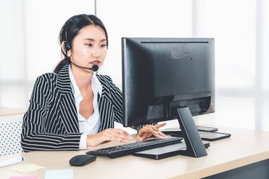 Ofiste çalışan kulaklık takan işadamları uzak müşteri ya da meslektaşlarını desteklemek için çalışıyorlar. Arama merkezi, tele pazarlama, müşteri destek acentesi telefon görüşmesinde hizmet sunar.