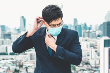 Coronavirus veya COVID-19 yüzünden yüz maskesi olan genç bir ofis çalışanı. Coronavirus veya COVID-19 'un yayılmasını engellemek ve işletmeyi yeniden açmak için koruyucu çalışma ortamı kavramı.