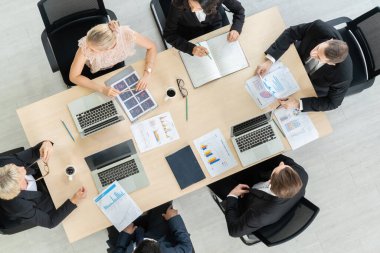 İş adamları grup toplantısı ofiste yukarıdan çekildi. İş kadınları, iş adamları ve ofis çalışanları, proje planlama belgeleriyle takım konferansında toplantı masasında çalışıyorlar. .