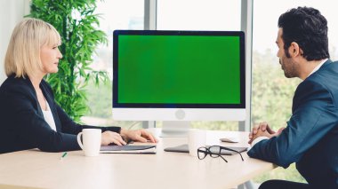 Konferans odasındaki iş adamları yeşil ekran krom anahtar televizyonlu ya da ofis masasında bilgisayar olan kişiler. Çeşitli iş adamları ve iş kadınları video konferansında bir araya geldi. .