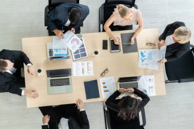 İş adamları grup toplantısı ofiste yukarıdan çekildi. İş kadınları, iş adamları ve ofis çalışanları, proje planlama belgeleriyle takım konferansında toplantı masasında çalışıyorlar. .