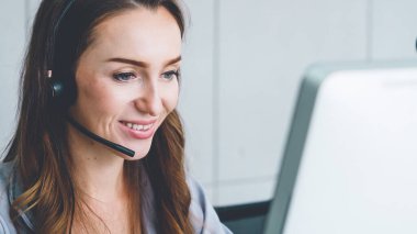 Ofiste çalışan kulaklık takan işadamları uzak müşteri ya da meslektaşlarını desteklemek için çalışıyorlar. Arama merkezi, tele pazarlama, müşteri destek acentesi telefon görüşmesinde hizmet sunar.