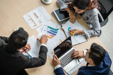 İş adamları grup toplantısı ofiste yukarıdan çekildi. İş kadınları, iş adamları ve ofis çalışanları, proje planlama belgeleriyle takım konferansında toplantı masasında çalışıyorlar. .