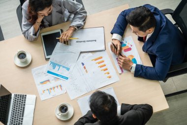 İş adamları grup toplantısı ofiste yukarıdan çekildi. İş kadınları, iş adamları ve ofis çalışanları, proje planlama belgeleriyle takım konferansında toplantı masasında çalışıyorlar. .