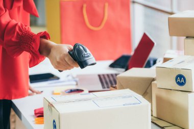 Çevrimiçi satıcı ev ofisinde çalışıyor ve teslimat kutusunu müşteriye paketliyor. İnternette e-ticaret yapan küçük işletme sahibi ya da girişimci.