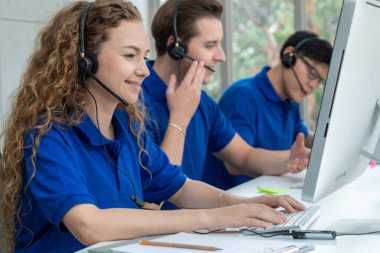 Ofiste çalışan kulaklık takan işadamları uzak müşteri ya da meslektaşlarını desteklemek için çalışıyorlar. Arama merkezi, tele pazarlama, müşteri destek acentesi telefon görüşmesinde hizmet sunar.
