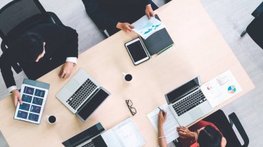 İş adamları grup toplantısı ofiste yukarıdan çekildi. İş kadınları, iş adamları ve ofis çalışanları, proje planlama belgeleriyle takım konferansında toplantı masasında çalışıyorlar. .