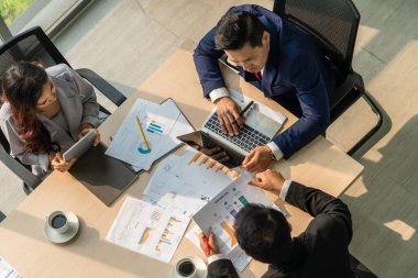 İş adamları grup toplantısı ofiste yukarıdan çekildi. İş kadınları, iş adamları ve ofis çalışanları, proje planlama belgeleriyle takım konferansında toplantı masasında çalışıyorlar. .