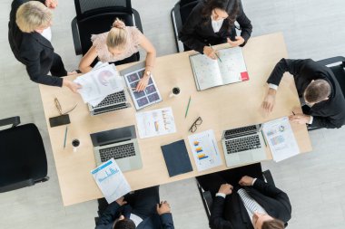 İş adamları grup toplantısı ofiste yukarıdan çekildi. İş kadınları, iş adamları ve ofis çalışanları, proje planlama belgeleriyle takım konferansında toplantı masasında çalışıyorlar. .