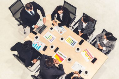 İş adamları grup toplantısı ofiste yukarıdan çekildi. İş kadınları, iş adamları ve ofis çalışanları, proje planlama belgeleriyle takım konferansında toplantı masasında çalışıyorlar. .