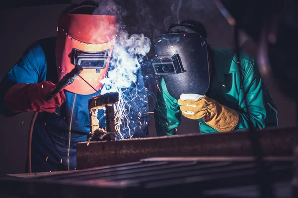 Metal welding steel works using electric arc welding machine to weld steel at factory. Metalwork manufacturing and construction maintenance service by manual skill labor concept.